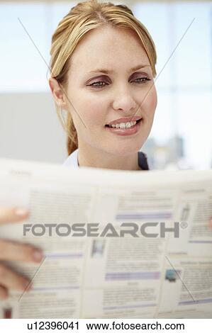 Stock Image - Businesswoman reading document. Fotosearch