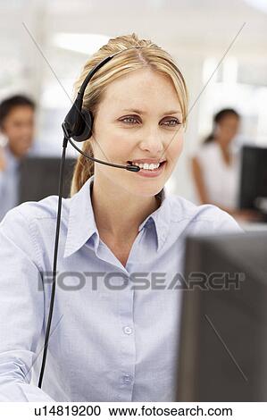 Stock Image - Businesswoman wearing headset. Fotosearch