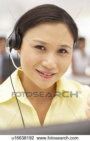 Stock Image - Businesswoman wearing headset. Fotosearch