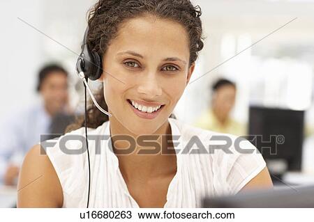 Stock Image - Businesswoman wearing headset. Fotosearch