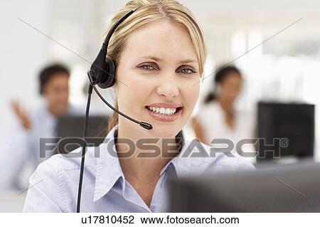 Stock Image - Businesswoman wearing headset. Fotosearch