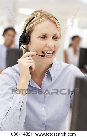 Stock Image - Businesswoman wearing headset. Fotosearch