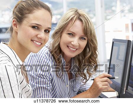 Businesswomen working on computers View Large Photo Image Stock Photograph - Businesswomen working on computers. Fotosearch