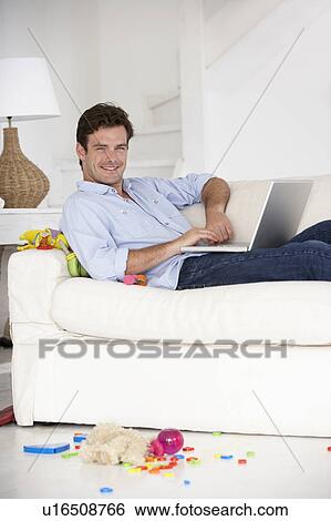 Busy father working on laptop View Large Photo Image Stock Photograph - Busy father working on laptop. Fotosearch
