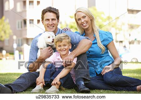 Stock Image - Couple in city park with young son and dog. Fotosearch