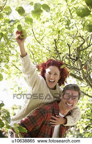 Stock Photography - Couple picking apples off tree. Fotosearch
