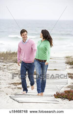 Stock Photo - Couple running along beach path. Fotosearch