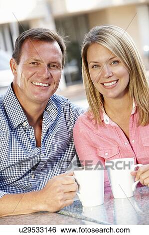Stock Photograph - Couple sitting at sidewalk cafÃ©. Fotosearch