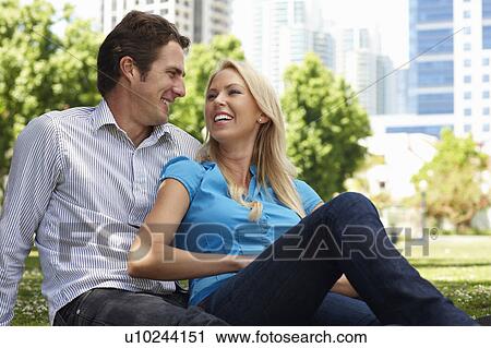Stock Image - Couple sitting in city park. Fotosearch