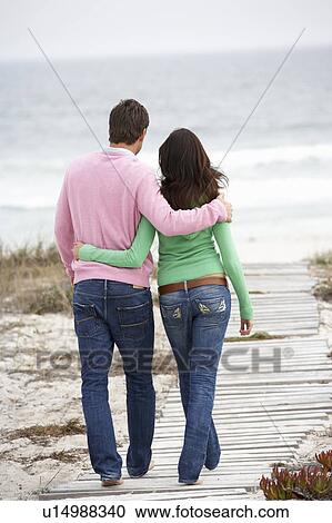 Stock Image - Couple walking by the sea. Fotosearch