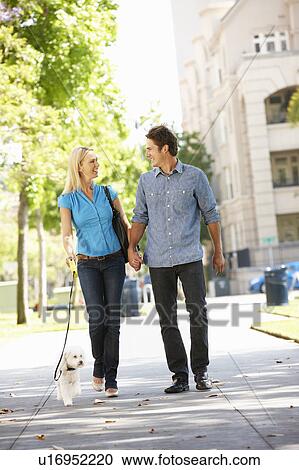 Couple walking with dog in city street View Large Photo Image Stock Image - Couple walking with dog in city street. Fotosearch