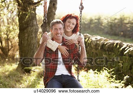 Couple with country garden swing View Large Photo Image Stock Photograph - Couple with country garden swing. Fotosearch