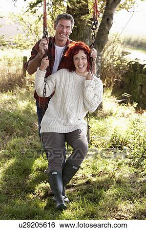 Stock Photograph - Couple with country garden swing. Fotosearch