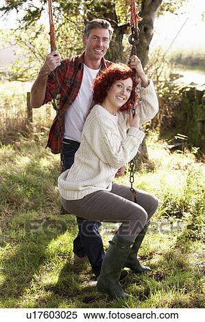 Stock Photography - Couple with country garden swing. Fotosearch