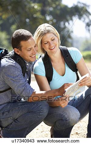 Stock Image - Couple with map on country walk. Fotosearch