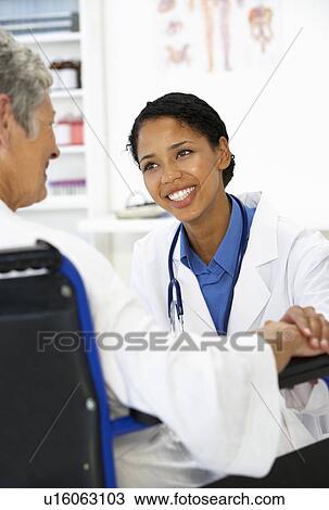 Stock Image - Doctor with female patient. Fotosearch