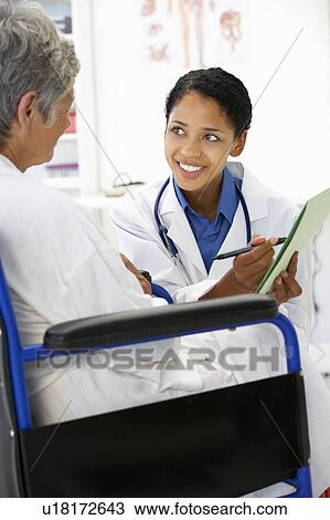 Stock Image - Doctor with female patient. Fotosearch