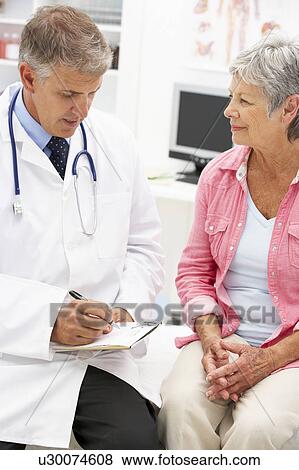 Doctor with female patient View Large Photo Image Stock Photo - Doctor with female patient. Fotosearch