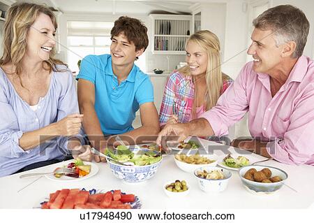 Stock Image - Family enjoying meal at home. Fotosearch