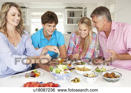 Stock Photograph - Family enjoying meal at home. Fotosearch