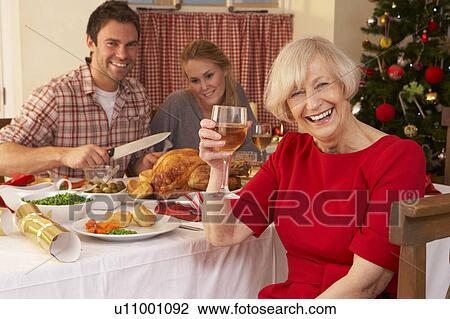 Stock Image - Family having Christmas dinner. Fotosearch
