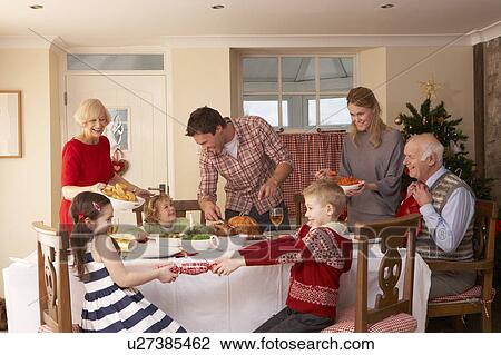 Stock Image - Family serving Christmas dinner. Fotosearch
