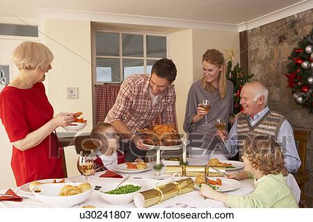 Stock Photo - Family serving Christmas dinner. Fotosearch