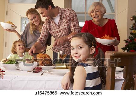 Stock Photography - Family serving Christmas dinner. Fotosearch