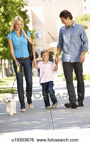 Stock Photograph - Family walking with dog in city street. Fotosearch