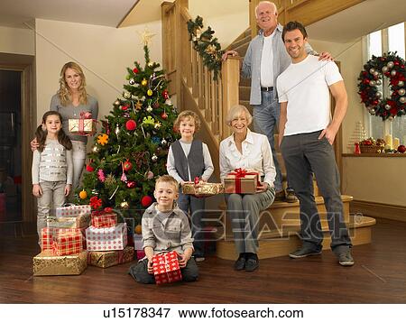Stock Photo - Family with gifts around the Christmas tree. Fotosearch