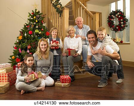 Family with gifts in front of Christmas tree View Large Photo Image Stock Image - Family with gifts in front of Christmas tree. Fotosearch