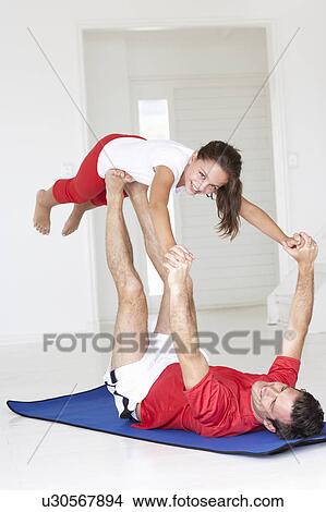 Picture - Father and daughter doing yoga lift. Fotosearch
