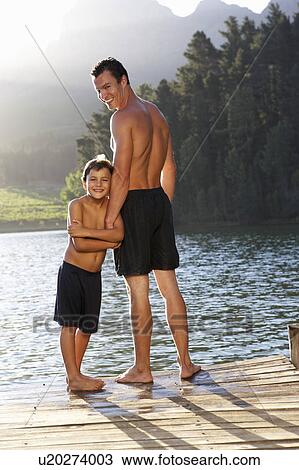 Father and son standing on jetty View Large Photo Image Stock Image - Father and son standing on jetty. Fotosearch