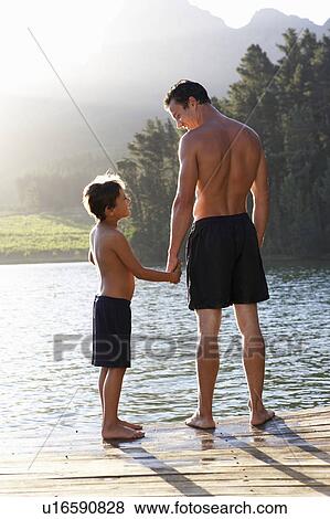 Father and son standing on jetty View Large Photo Image Stock Photo - Father and son standing on jetty. Fotosearch