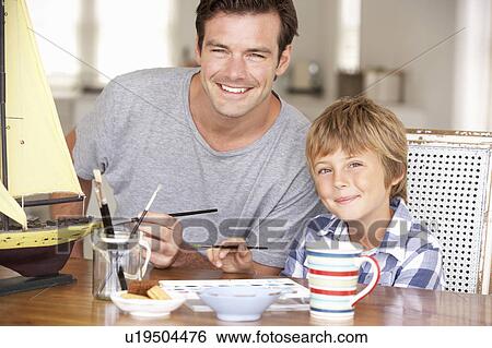 Stock Photograph - Father model making with son. Fotosearch