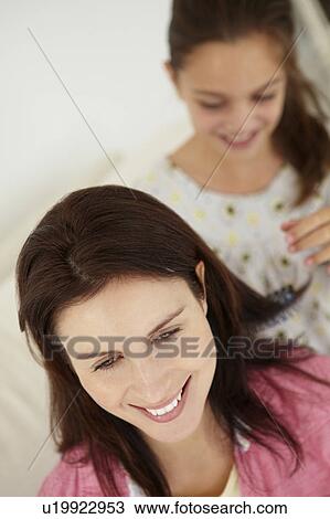Stock Image - Girl brushing mother's hair. Fotosearch