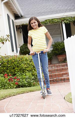 Girl in garden with scooter View Large Photo Image Stock Photo - Girl in garden with scooter. Fotosearch
