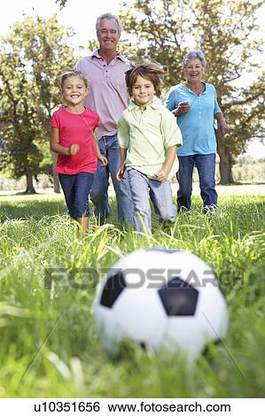 Stock Photograph - Grandparents playing football with grandchilderen. Fotosearch