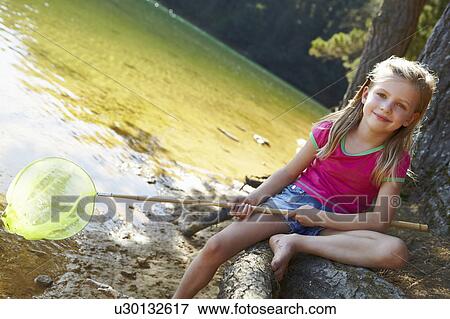 Stock Photo - Happy girl fishing at lake. Fotosearch