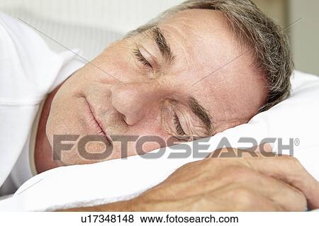 Stock Photo - Head and shoulders mid age man sleeping. Fotosearch