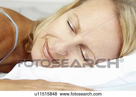 Stock Photo - Head and shoulders mid age woman sleeping. Fotosearch