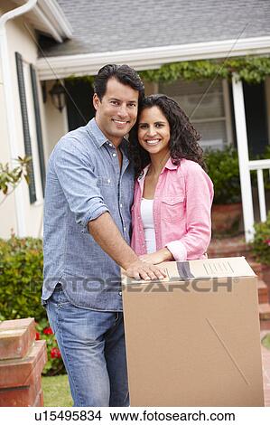 Picture - Hispanic couple moving into new house. Fotosearch