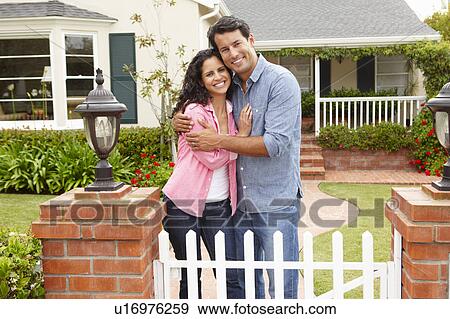 Stock Photo - Hispanic couple outside home. Fotosearch