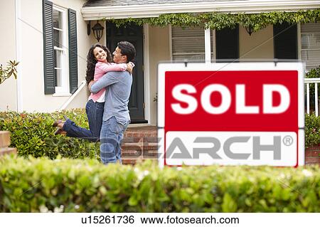 Hispanic couple outside home with sold sign View Large Photo Image Stock Photograph - Hispanic couple outside home with sold sign. Fotosearch