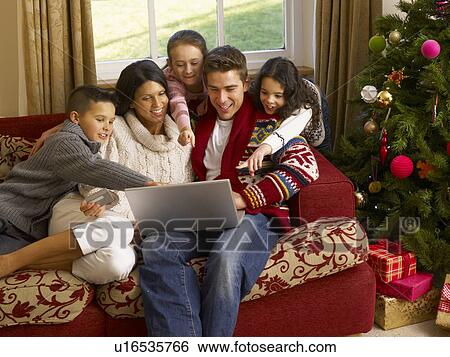 Stock Photograph - Hispanic family Christmas shopping online. Fotosearch