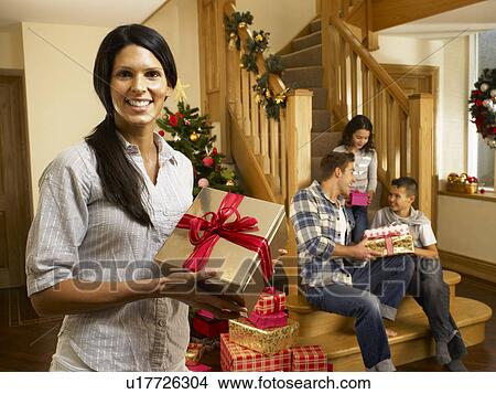 Picture - Hispanic family exchanging gifts at Christmas. Fotosearch