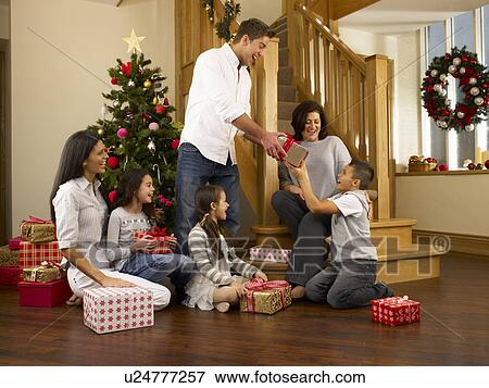 Hispanic family exchanging gifts at Christmas View Large Photo Image Stock Photo - Hispanic family exchanging gifts at Christmas. Fotosearch