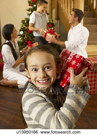 Stock Photograph - Hispanic family exchanging gifts at Christmas. Fotosearch