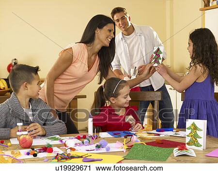 Stock Image - Hispanic family making Christmas cards. Fotosearch