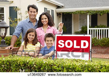 Hispanic family outside home with sold sign View Large Photo Image Stock Photo - Hispanic family outside home with sold sign. Fotosearch
